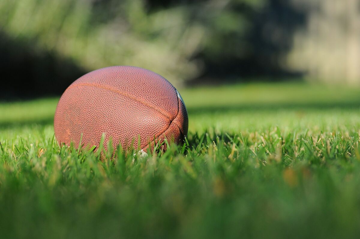 Football resting in the grass before a flag football game