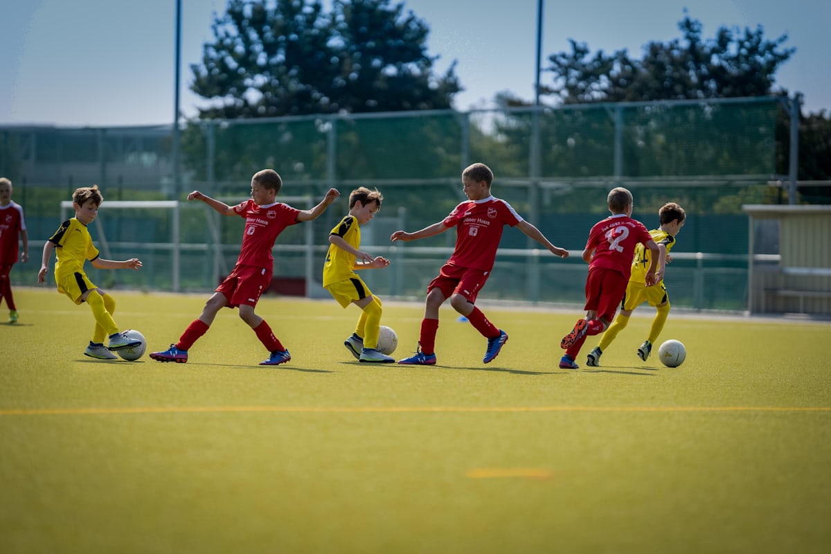 Youth soccer players mid-game on a sunny field